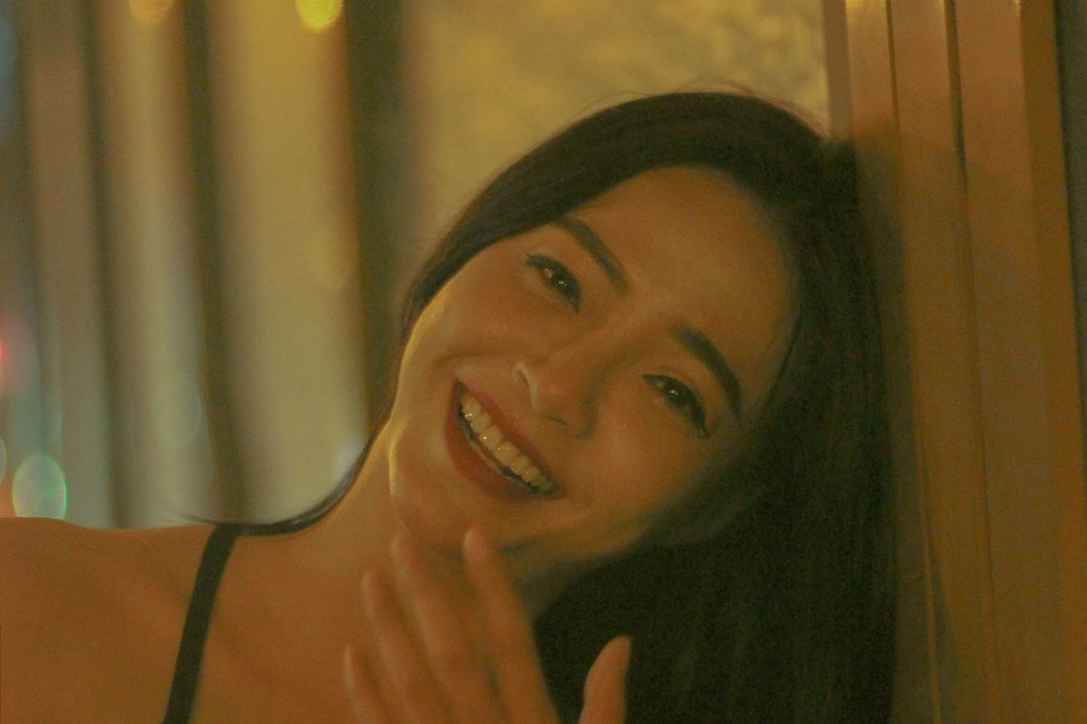 Juno Park laughing on a rainy Seoul street